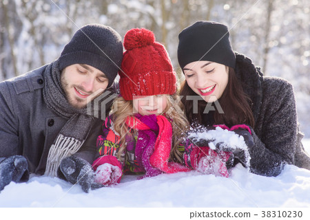 Happy family laying on snow in winter forest Happy family laying on snow in winter forest 38310230