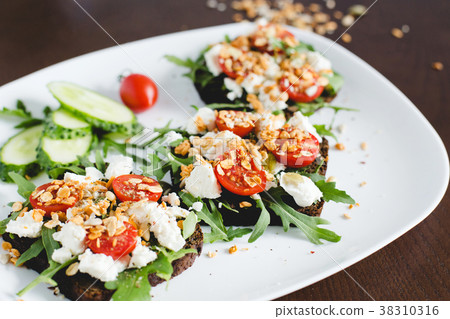 Three sandwiches of dark bread on a white plate. Three sandwiches of dark bread on a white plate. 38310316