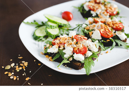 Three sandwiches of dark bread on a white plate. Three sandwiches of dark bread on a white plate. 38310317