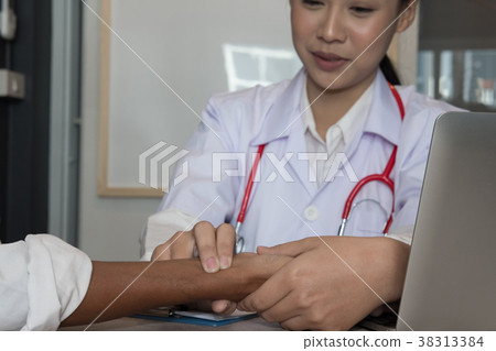 doctor check heart rate pulse on patient wrist at hospital. physician measure pulsation. health care check up 38313384