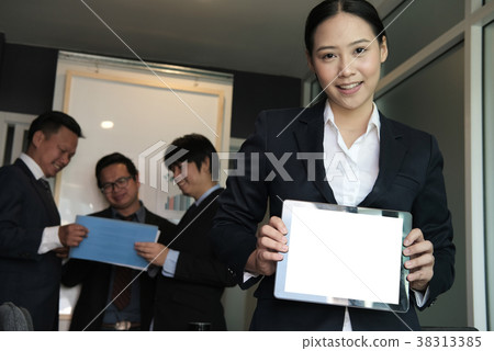 businesswoman hold tablet at workplace. young woman shows information in touchpad at office. freelancer present data in business meeting 38313385