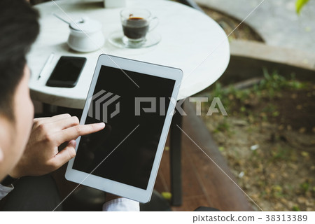 businessman in suit holding touchpad while sitting at cafe. young asian startup man using digital tablet for work at coffee shop 38313389