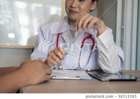 female doctor show pills to patient at medical office. physician explain drug to a man. healthcare, treatment concept female doctor show pills to patient at medical office. physician explain drug to a man. healthcare, treatment concept 38313393