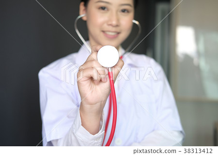 female doctor showing stethoscope for checkup at clinic. physician or medical practitioner holding stethoscope to auscultate breath in medical visit 38313412