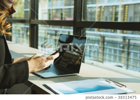 businesswoman holding mobile phone texting message at office. young female entrepreneur using smartphone at cafe. freelance woman working with cellphone at coffee shop. business concept businesswoman holding mobile phone texting message at office. young female entrepreneur using smartphone at cafe. freelance woman working with cellphone at coffee shop. business concept 38313475
