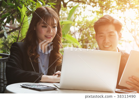 young business people having a meeting. businessman & businesswoman working with computer at cafe. startup man & freelance woman discussing idea at coffee shop. discussion, teamwork, collaboration, corporate concept. young business people having a meeting. businessman & businesswoman working with computer at cafe. startup man & freelance woman discussing idea at coffee shop. discussion, teamwork, collaboration, corporate concept. 38313490