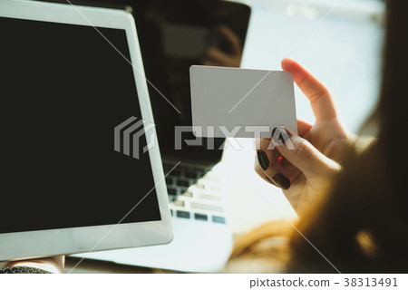 woman holding a credit card and using tablet for online shopping at cafe. businesswoman purchase goods from internet at office. female adult make payment on bank website at workplace 38313491