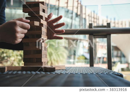 hand pull out wood block from tower. growth, risk & strategy in business. 38313916