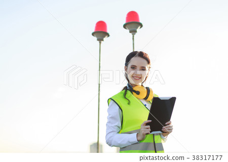 Young woman in green west and earmuffs stand on Young woman in green west and earmuffs stand on 38317177