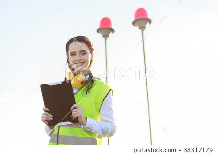 Young woman in green west and earmuffs stand on Young woman in green west and earmuffs stand on 38317179