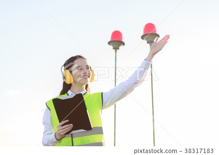 Young woman in green west and earmuffs stand on Young woman in green west and earmuffs stand on 38317183