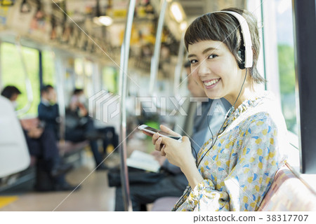 Woman listening to music by train Woman listening to music by train 38317707
