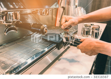 Barista prepare a cofee for extract in machine. Barista prepare a cofee for extract in machine. 38318387