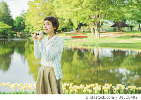 Young woman taking a picture in a flower field 38318492