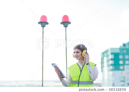 Young pretty woman in green west and earmuffs Young pretty woman in green west and earmuffs 38318839