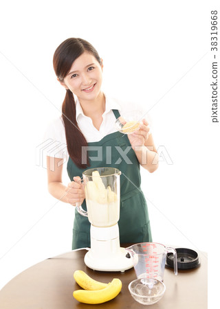 A woman making a smoothie 38319668