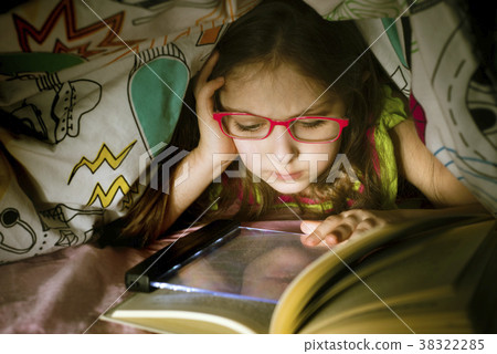 Little caucasian girl reading a book under Little caucasian girl reading a book under 38322285