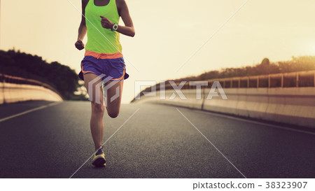 fitness asian woman runner running on city road 38323907