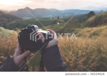 Photographer taking photo of mountain in morning 38324928