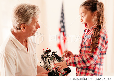Emotional little girl getting excited over robot Emotional little girl getting excited over robot 38326052