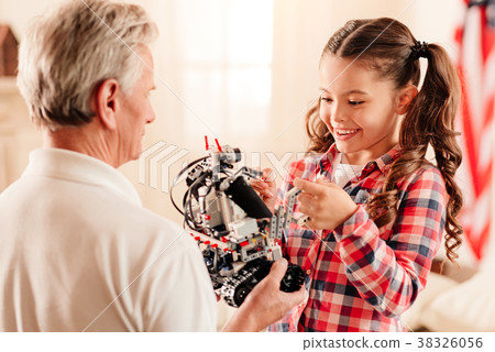 Charming preteen kid examining robotic machine Charming preteen kid examining robotic machine 38326056