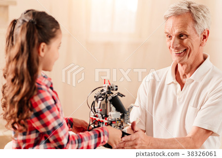 Radiant elderly man giving his granddaughter Radiant elderly man giving his granddaughter 38326061
