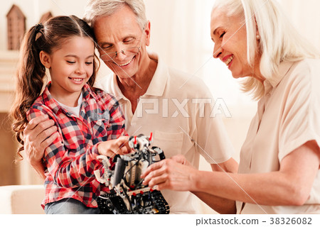 Harmonious family beaming while gazing on robot Harmonious family beaming while gazing on robot 38326082