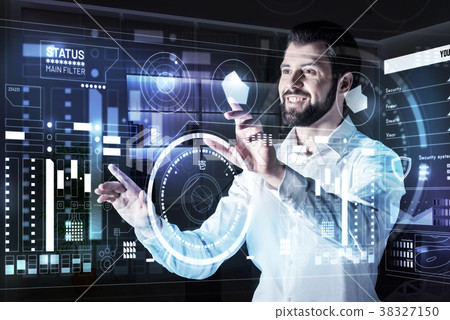 Positive man smiling while touching a futuristic Positive man smiling while touching a futuristic 38327150