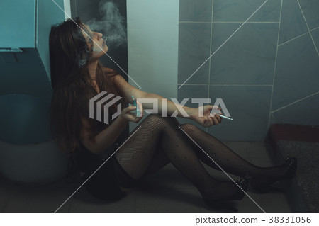 Woman drug addict makes an injection. 38331056