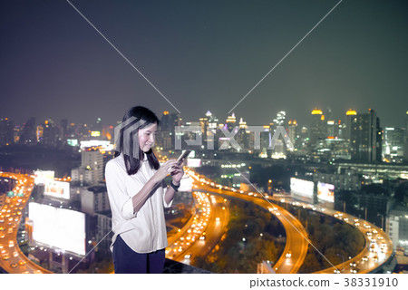 Asian business woman using a smartphone on rooftop in Bangkok Ci Asian business woman using a smartphone on rooftop in Bangkok Ci 38331910