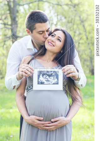 couple with a photo of a child couple with a photo of a child 38332102
