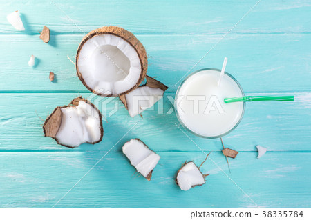 Glass of coconut milk on blue wooden table Glass of coconut milk on blue wooden table 38335784