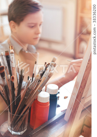 Serious teen boy painting masterpiece in studio Serious teen boy painting masterpiece in studio 38336200