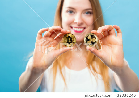 Woman holding physical bitcoin and ripple coins 38336249