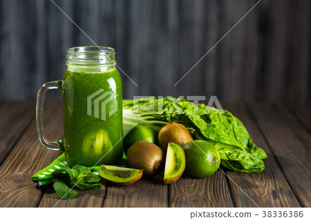 Blended green smoothie with ingredients on wooden Blended green smoothie with ingredients on wooden 38336386