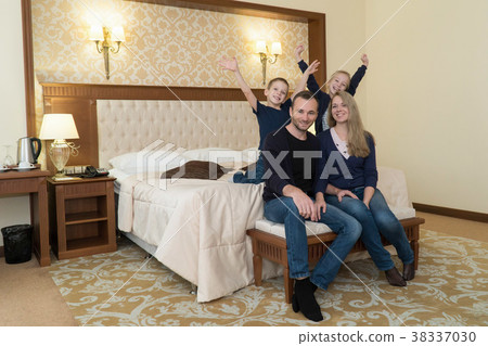 a happy family posing on camera in hotel room a happy family posing on camera in hotel room 38337030