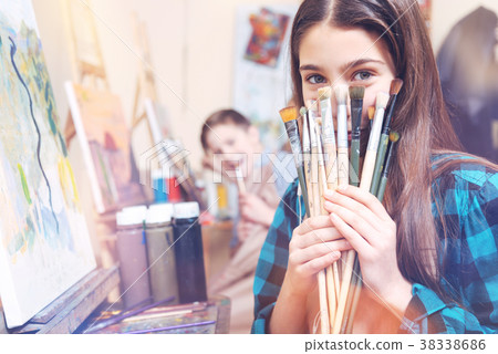 Pretty young lady showing bunch of old painting Pretty young lady showing bunch of old painting 38338686
