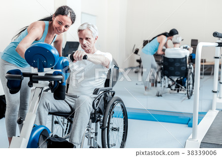 Serious old man exercising while sitting in a 38339006