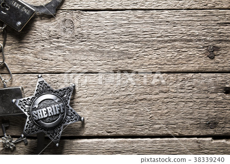Sheriff star and handcuffs on wooden table 38339240