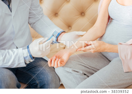 Concentrated responsible doctor sitting and making 38339352