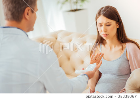 Disappointed serious woman looking at pills and 38339367