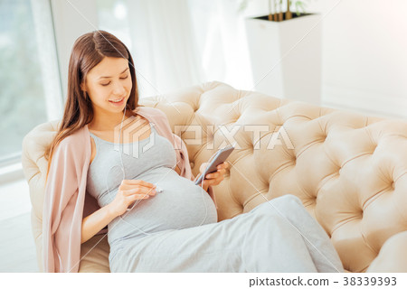 Satisfied calm woman lying and listening to music. 38339393