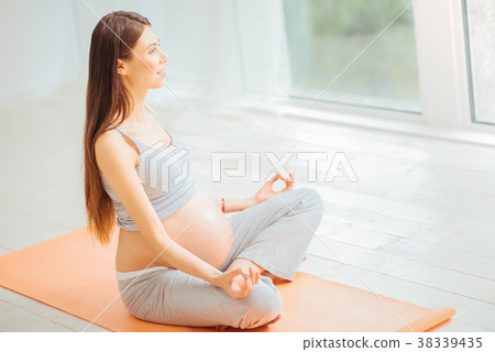 Pleasant young woman mediating on the floor and 38339435