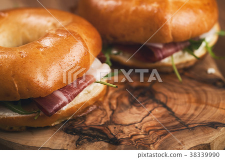 two bagels with prosciutto and cream cheese on 38339990