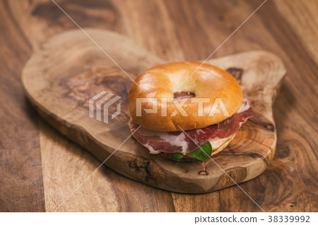bagel with coppa and cream cheese on wood boar 38339992