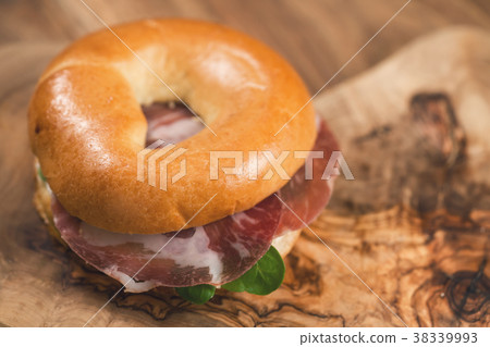 bagel with coppa and cream cheese on wood boar 38339993