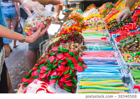 Customers choose sweets from counter Customers choose sweets from counter 38340508