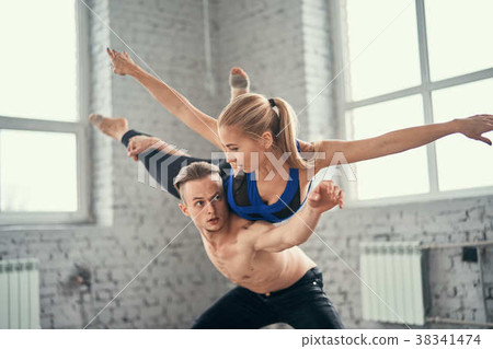 A young couple of dancers perform complex tricks A young couple of dancers perform complex tricks 38341474