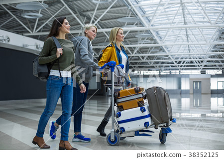 Enjoyed companions carrying luggage on airport 38352125