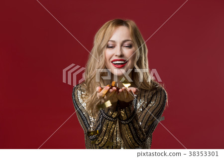 Playful woman with shiny pieces of paper Playful woman with shiny pieces of paper 38353301